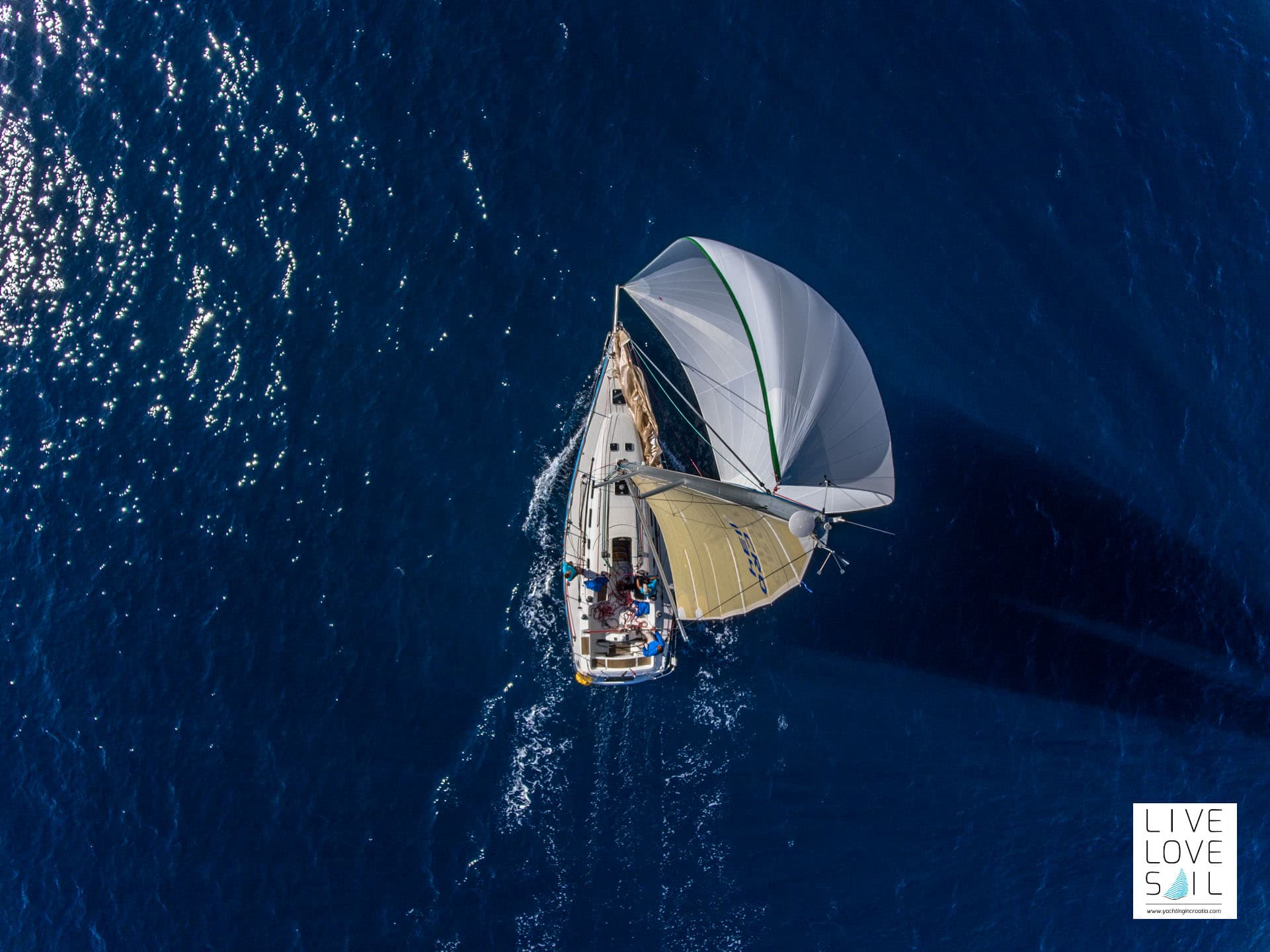 Top view of a sailing boat on a deep blue water