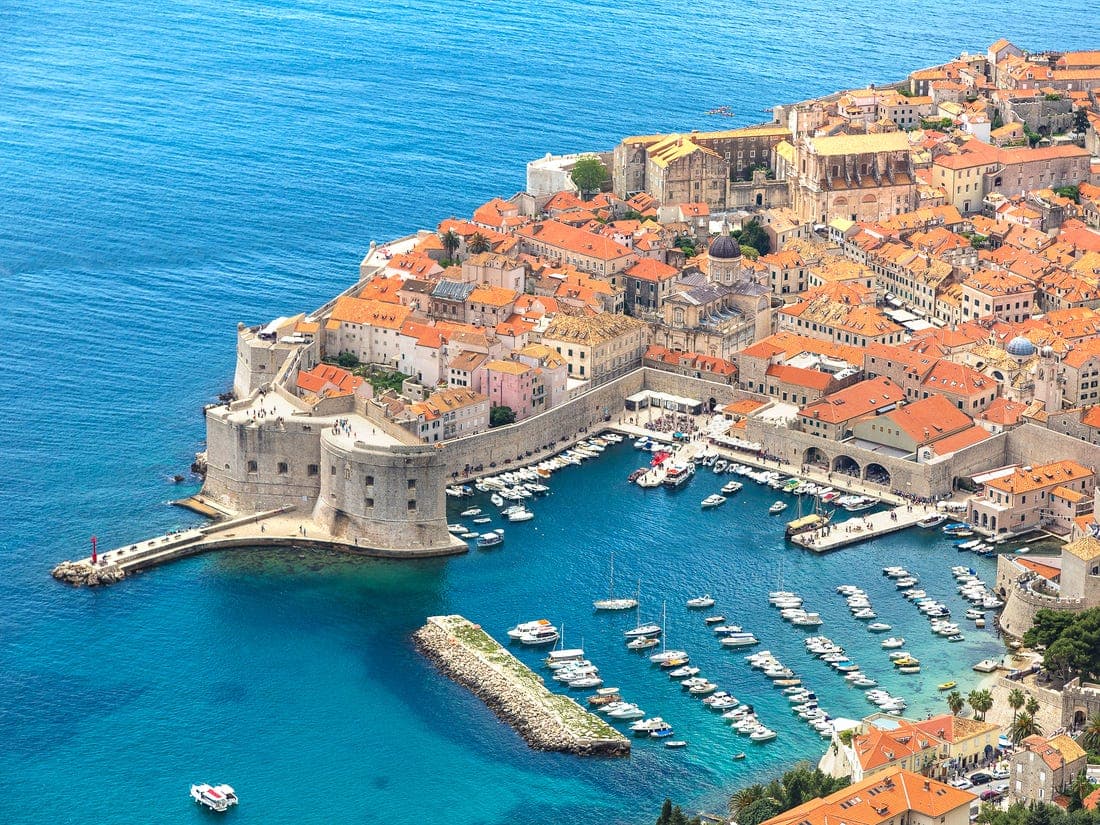 Aerial shot of a historical town with marina in front