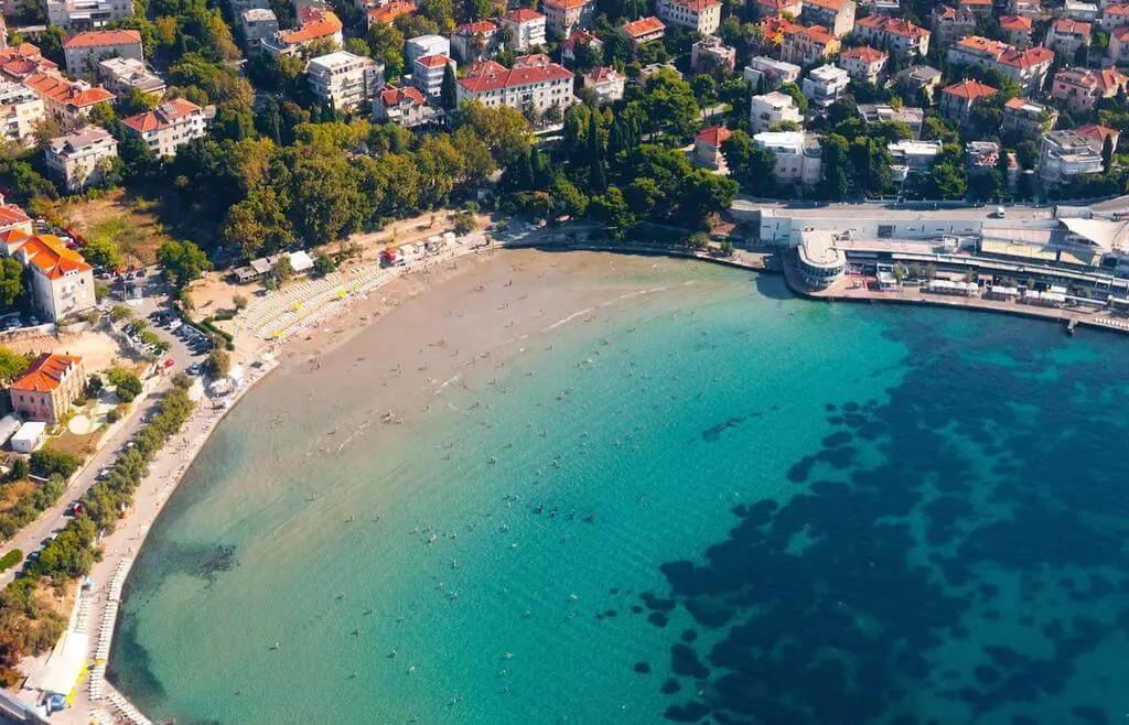 Bacvice in Croatia with deep blue sea and town buildings