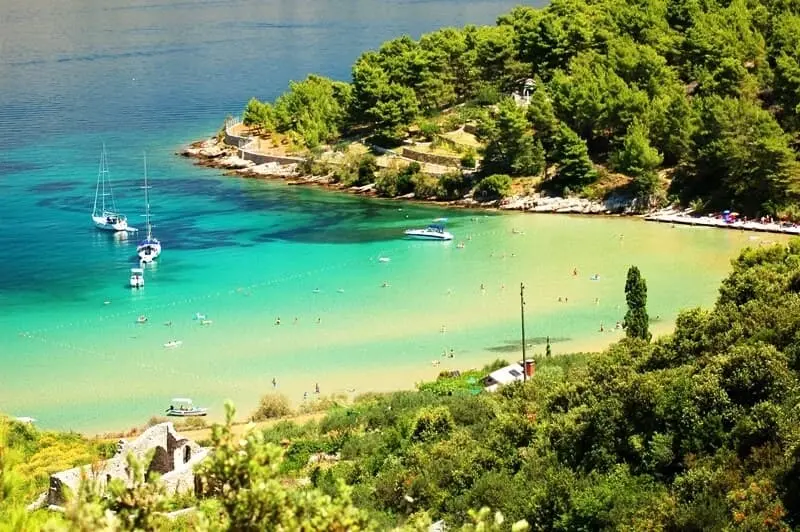 Lovrecina beach in Croatia with yachts sailing close to the shore