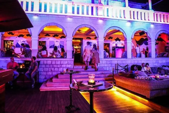 Carpe diem club on Hvar with pink lights and people clubbing