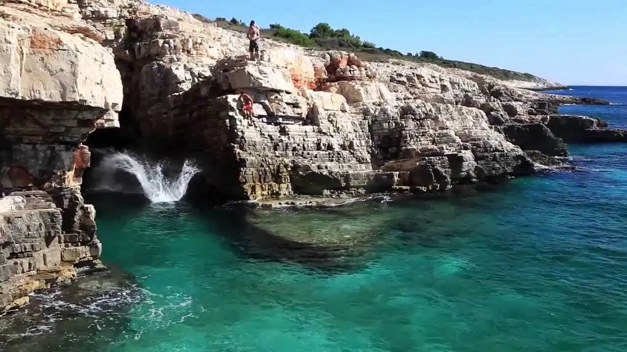 Kamenjak cove with people climbing on it